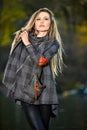 Beautiful young fashion model wearing coat and leggings posing in the autumn park Royalty Free Stock Photo