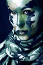 Beautiful young fashion woman with military style clothing and face paint make-up, khaki colors, halloween celebration Royalty Free Stock Photo