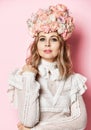 Beautiful young fashion woman portrait with delicate roses flowers in hair with flower wreath on pink Royalty Free Stock Photo