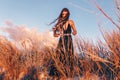 Beautiful young fashionable woman on the beach at sunset