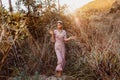 Beautiful young fashionable woman in dress on the field at sunset Royalty Free Stock Photo