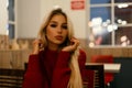 Beautiful young fashionable woman in a red sweater sits Royalty Free Stock Photo