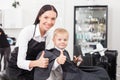 Beautiful young female barber is working in salon