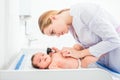 Beautiful young female blonde doctor examining little baby with ear speculum in clinic. Baby health concept Royalty Free Stock Photo