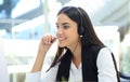 Beautiful young female call center operator with headset in office. Royalty Free Stock Photo