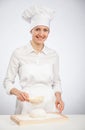 Beautiful young female cook powdering dough with flour Royalty Free Stock Photo