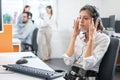 Beautiful young female customer services agent listening to a client via headset at call center Royalty Free Stock Photo