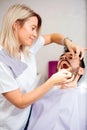 Beautiful young female dentist examining young male patient in dental clinic Royalty Free Stock Photo