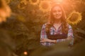 Beautiful, young female farmer smiling in the middle of a sunflower field during sunrise Royalty Free Stock Photo