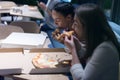 Beautiful young female friends woman eating pizza and drinking cola while sitting inside expres restaurant late at night Royalty Free Stock Photo