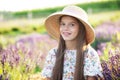 Beautiful young female girl smile with big straw summer hat, sits on lavender field, has rest after strolling outdoors at sunny ho Royalty Free Stock Photo