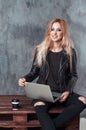 Beautiful young female girl using portable laptop computer while sitting in a vintage place and drinking coffee. Royalty Free Stock Photo