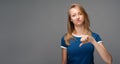 Beautiful young female looking is upset at the camera, holding thumb down. Concept of dislike Royalty Free Stock Photo