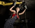 Beautiful young female mechanic inspecting car in auto repair shop. mechanic Royalty Free Stock Photo