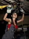 Beautiful young female mechanic inspecting car in auto repair shop. mechanic Royalty Free Stock Photo