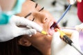 Beautiful young female patient receiving dental care in dental clinic