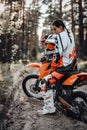 Beautiful young female racer riding motocross bike on a trail of sand in the woods Royalty Free Stock Photo