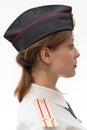 A beautiful young female Russian police officer in dress uniform in a cap and shoulder straps of a lieutenant colonel and a white