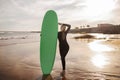 Beautiful young female surfer posing with her surfboard at the beach Royalty Free Stock Photo