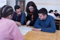 Beautiful young female teacher helping a student during class. Female Professor Holding Lecture to Multi Ethnic Group of Students