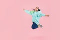 Beautiful young fit dancer in blue hoodie dancing and jumping isolated on pink background Royalty Free Stock Photo