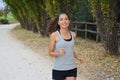 Beautiful young fitness woman running in the park. Smiling girl training outdoors Royalty Free Stock Photo
