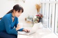 Beautiful young freelance asian woman smiling working and on laptop computer at desk coffee shop with professional