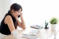 Beautiful young freelance asian woman smiling working on laptop computer and talking mobile smart phone at desk Royalty Free Stock Photo