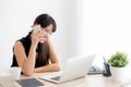 Beautiful young freelance asian woman smiling working on laptop computer and talking mobile smart phone at desk