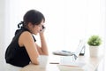 Beautiful young freelance asian woman smiling working on laptop computer and talking mobile smart phone Royalty Free Stock Photo