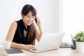 Beautiful young freelance asian woman smiling working on laptop computer and talking mobile smart phone Royalty Free Stock Photo