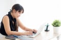 Beautiful young freelance asian woman smiling working and typing on laptop computer at desk office with professional Royalty Free Stock Photo