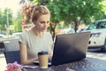 Beautiful young freelancer caucasian woman using laptop computer sitting at cafe. Happy smiling blonde girl working online or stud Royalty Free Stock Photo