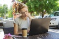 Beautiful young freelancer caucasian woman using laptop computer sitting at cafe. Happy smiling blonde girl working online or stud Royalty Free Stock Photo