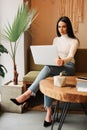 Beautiful young freelancer woman using laptop computer while sitting at cafe. Royalty Free Stock Photo