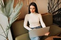 Beautiful young freelancer woman using laptop computer while sitting at cafe. Royalty Free Stock Photo