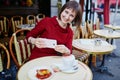 French woman drinking coffee in Parisian cafe and making photo Royalty Free Stock Photo