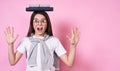 Beautiful young funny girl in glasses holds books on her head on a pink background Royalty Free Stock Photo