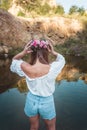 Beautiful young ginger fashion model boho style woman standing in lake in nature .Pretty young woman with Wreath of Pink Flowers