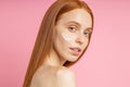 Beautiful young ginger woman with cream on face