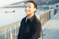 A beautiful young girl of African ethnicity with vitiligo standing on the warm spring city street dressed black coat Royalty Free Stock Photo