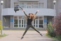 Beautiful young girl jumping on a university background