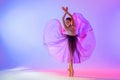 Beautiful young girl ballerina in pointe shoes and pink leotard silhouette on bright blue background Royalty Free Stock Photo