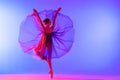 Beautiful young girl ballerina in pointe shoes and pink leotard silhouette on bright blue background Royalty Free Stock Photo