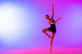 Beautiful young girl ballerina in pointe shoes and pink leotard silhouette on bright blue background Royalty Free Stock Photo