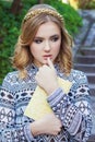 Beautiful young girl with blond hair and blue eyes holding a book in his hands