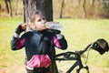 Beautiful young girl with blond hair drinking water on the go while cycling Royalty Free Stock Photo