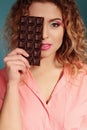 Beautiful young girl with blond hair and evening makeup eating chocolate Royalty Free Stock Photo