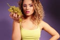 Beautiful young girl with blond hair and evening makeup with grapes Royalty Free Stock Photo