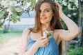 Beautiful young girl in a blue dress in a blooming Apple orchard. Blooming Apple trees with white flowers Royalty Free Stock Photo